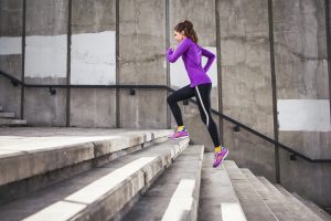 Hardloopster doet krachttraining door buiten een trap op te rennen.