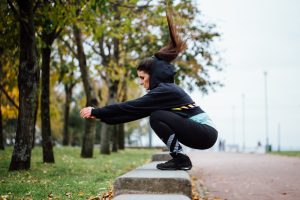 Hardloopster doet buiten krachttraining door op een bankje te springen.