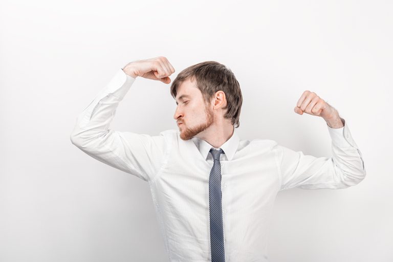 11-19-Lokale vibraties kunnen spierkracht verbeteren bij gezonde mensen_760448710 Man die op het kantoor stoer zijn biceps laat zien.