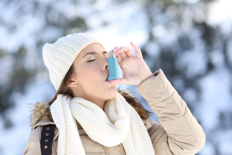 11-20-Dyspnoe en angst bij COPD verminderen door gedragsmatige benadering_768198043 Jonge dame die haar benauwdheid verlicht met een inhalator.