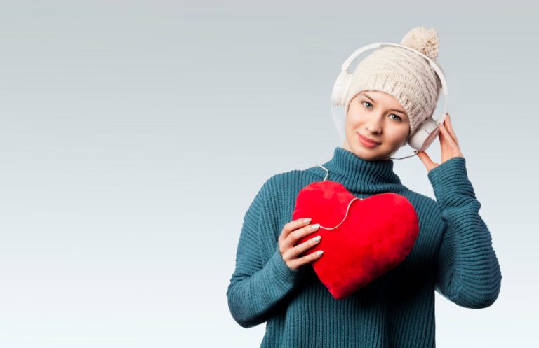 12-03-Hartslagvariabiliteit-biofeedback positief effect op mentale gezondheid bij chronisch vermoeidheidssyndroom_1013590840 Opgewekte vrouw draagt een hart voor zich en luistert naar muziek.