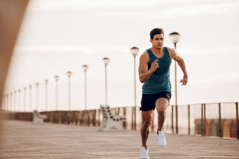 Hardloper zet een volle sprint op een kade langs zee.