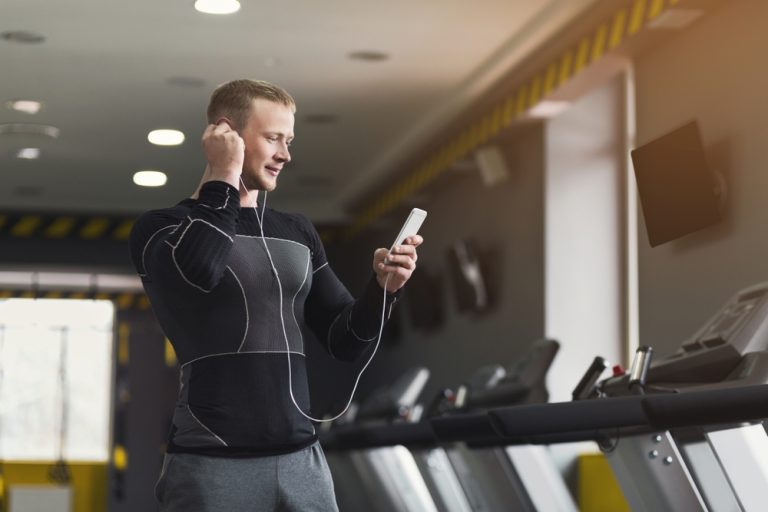 12-14-Pijntolerantie neemt toe als muziek zich aanpast aan het sportritme_1071783662 Jonge man traint met muziek op en heeft daardoor minder last van pijn.