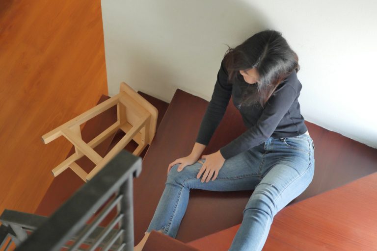 12-16-Migraine leidt tot grotere valangst en meer valincidenten_789680074 Valincident op de trap met pijn in de knie.