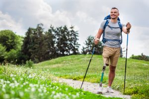 Man met onderbeen amputatie wandelt met veel plezier in de natuur.