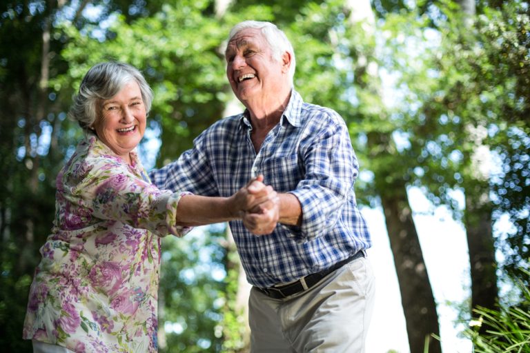 12-18-Dans als fysiotherapeutische beweeginterventie bij Parkinson_398384050 Ouder stel samen buiten aan het dansen om zo de coördinatie en het evenwicht op pijl te houden