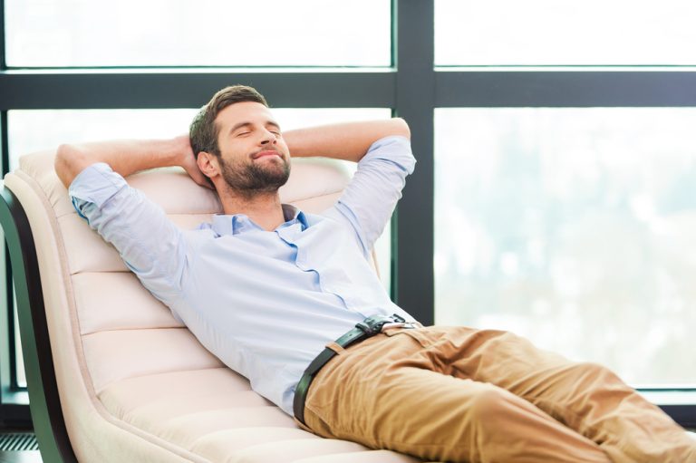 12-18-Mindfulness training toevoegen aan fysiotherapie is gunstig voor de geblesseerde sporter_237587071 Man doet bodyscan thuis op de bank om sneller te herstellen van zijn sportblessure.