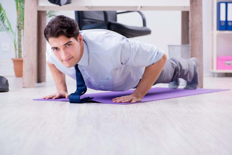 12-2-Actieve pauzes verminderen kans op rugklachten zonder verlies van productiviteit_1017390883 Man doet op zijn werk in de pauze push-ups en voorkomt daarmee rugklachten.