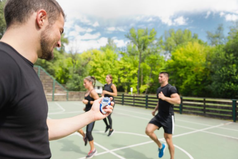 13-01-Je patiënt sportspecifiek motiveren _416991019 Trainer motiveert zijn hardlopers om vol te houden.