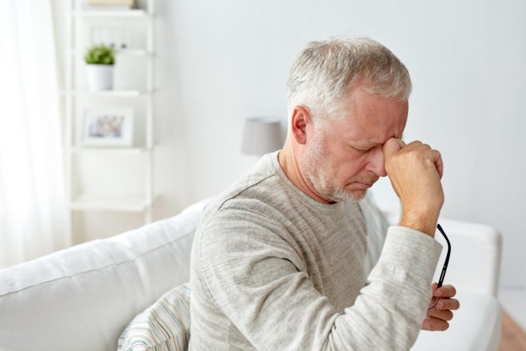 13-01-Stress verhoogt het risico op ziekte en is eenvoudig te signaleren_535283746 Gespannen man zit thuis op bank en is bezorgt.