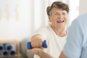 Prettige gesprek tussen patiënte en fysiotherapeut tijdens het oefenen.