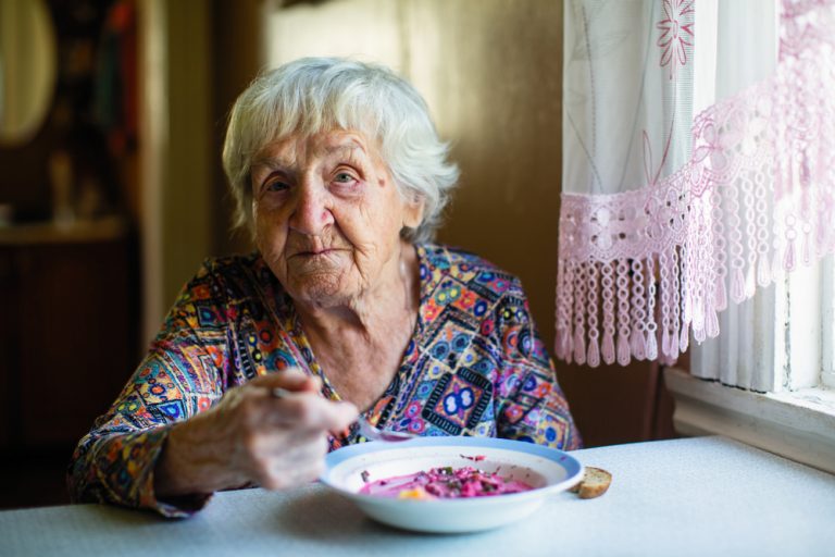 13-12-Hebben voedingssupplementen effect op het fysiek functioneren en spierkracht bij ouderen_1153120301 Oude vrouw aan het ontbijt voordat ze naar haar gymgroepje gaat.