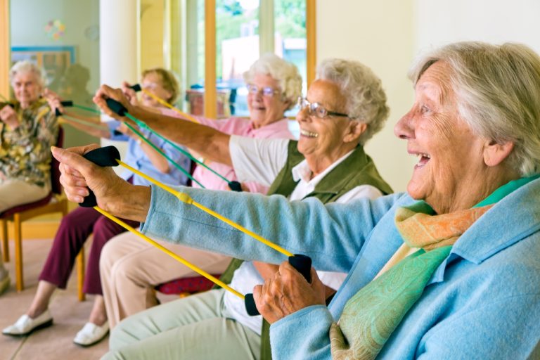 13-12-Kansen en barrières bij oefenprogramma’s voor ouderen_367740026 Gezellige oefengroep met oudere dames die gemotiveerd meedoen.