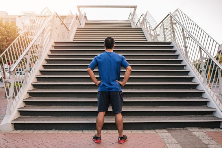 13-12-Vervangende trainingsvormen voor hardlopers_627946877 Hardloper die buiten vervangende trainingsarbeid doet bij een trap.