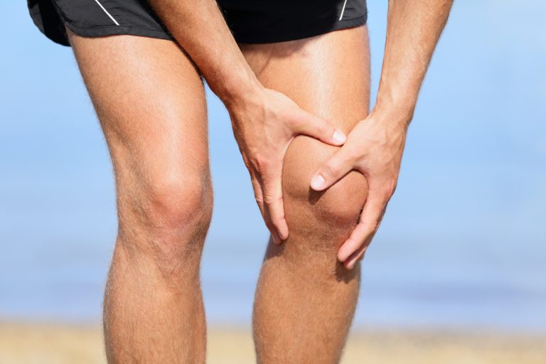 13-13-Spierfunctiestoornissen van de heupmusculatuur bij patellofemorale pijn194844245 Sporter grijpt naar pijnlijke knie die mogelijk relatie heeft met zijn heup.