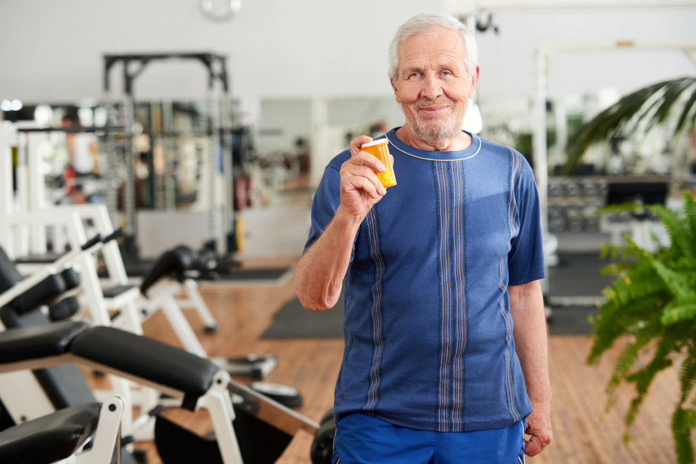 Blije oudere man die de bloeddrukverlagers laat zien die hij door sport nu minder nodig heeft.