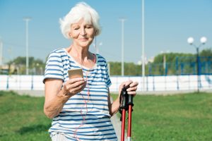 Vrouw houdt haar vorderingen met nordic walking bij op smartphone.
