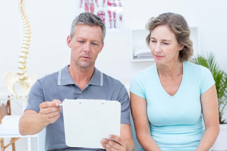 13-22-Bespreken van de verwachting beïnvloedt de uitkomst van fysiotherapie_270885305 Fysiotherapeut bespreekt de verwachtingen met de patiënt.