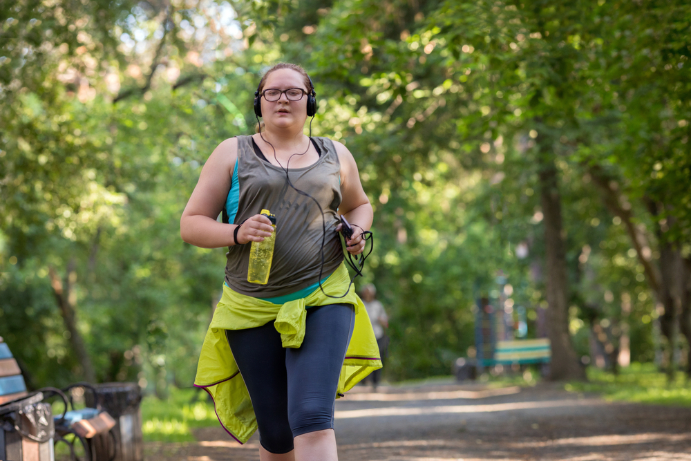 Obese dame aan het hardlopen in het park.