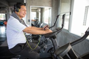 Man op hometrainer geniet van muziek tijdens zijn training.