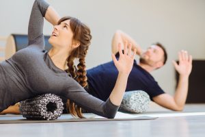 Jonge mensen bezig met pilates op de mat.