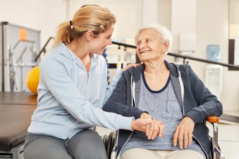 14-02-Fysiotherapie en ergotherapie verhogen kwaliteit van zorg in verpleeghuizen_1367320685 Oude patiënte toont dankbaarheid aan fysiotherapeute in het verpleegtehuis.