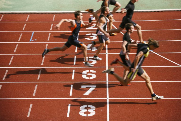 Athlets sprinting at finish line Sprint competition on running track. Finish line low angle view.