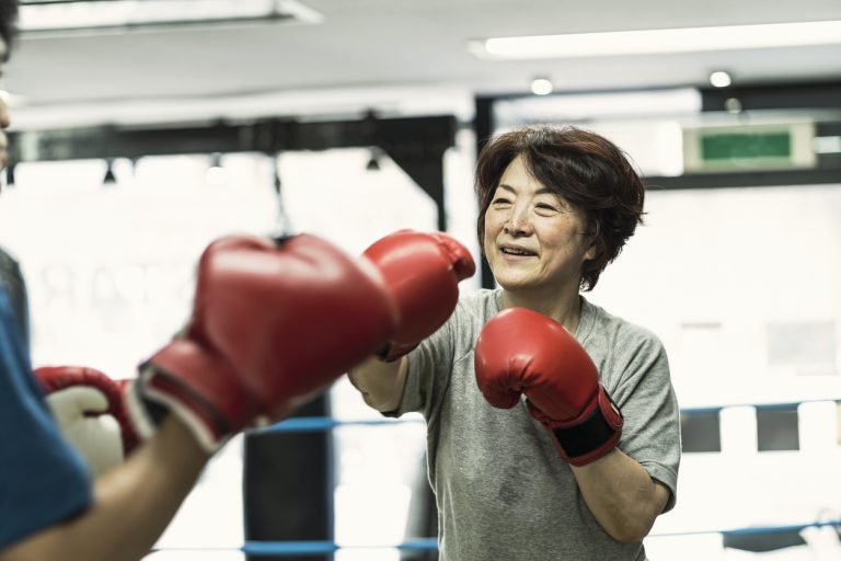 Senior adult women training with male instructor at boxing gym Japanese senior adult women training with male instructor at boxing gym