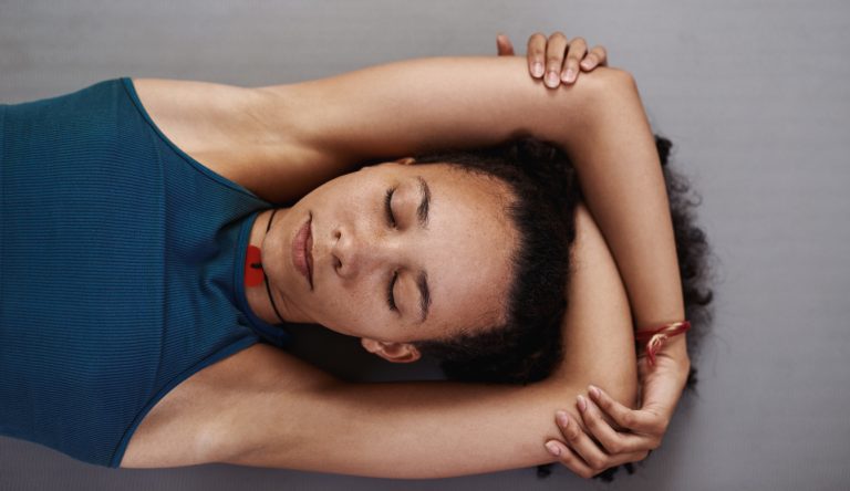 At ease yogi Shot of a young woman resting after her yoga session