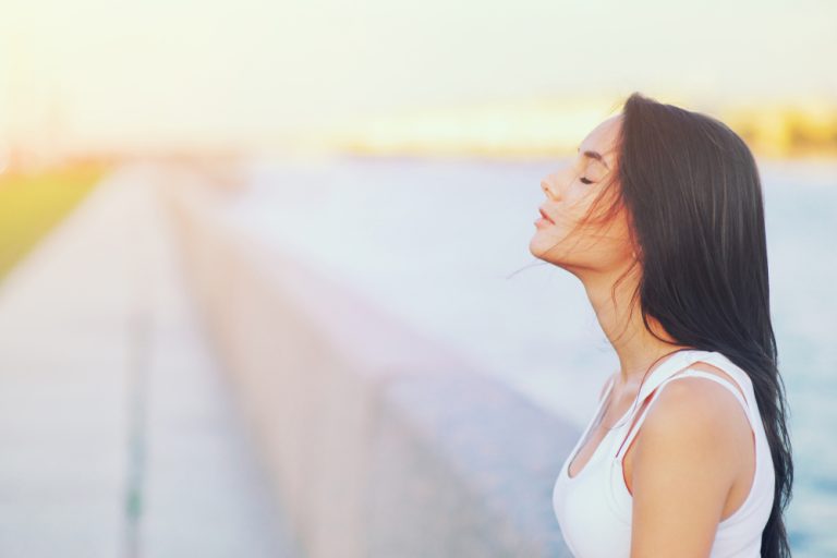 Side Side view profile portrait of a happy brunette woman relaxing breathing fresh air outdoors in summer Girl closed eyes doing deep breath exercises. Positive emotion success