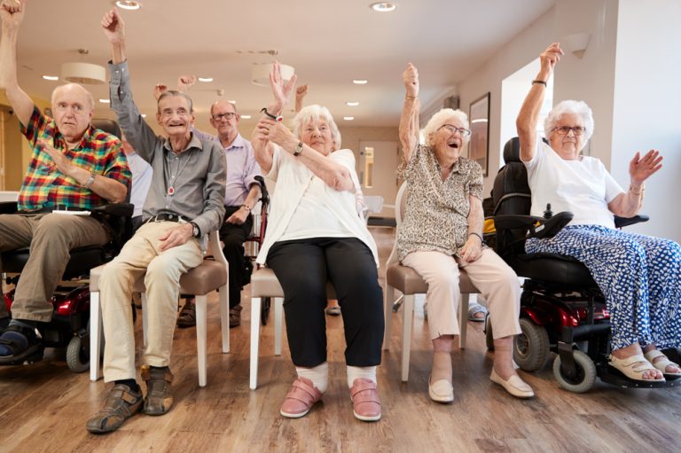 Senior Senior Woman Winning Game Of Bingo In Retirement Home