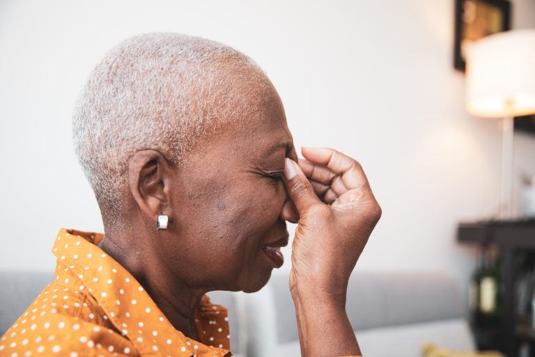 Senior Woman With a Headache senior African descent woman holding her head in pain