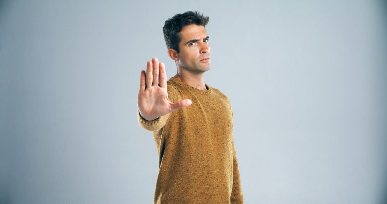 Hold it right there! Studio shot of a handsome young man gesturing to stop against a gray background