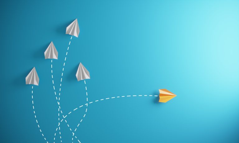 Different Approach - Different Direction Group of paper airplane in one direction and with one individual pointing in the different way