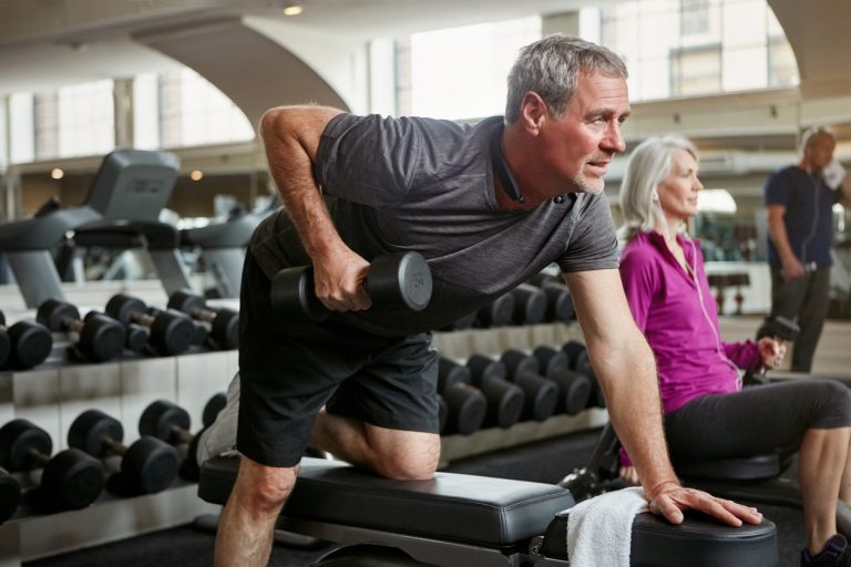 Strong arms look good at any age Shot of senior group of people working out together at the gym