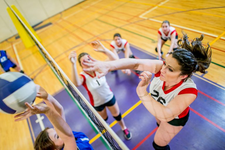 Girls Varsity Volleyball Girls having volleyball game indoor