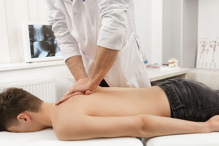 Manual Manual therapist doing manual adjustment on patient's spine. Chiropractic