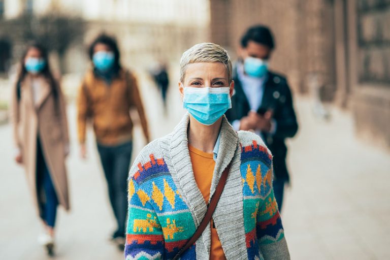 Woman with face protective mask Portrait of young woman on the street wearing face protective mask to prevent Coronavirus and anti-smog