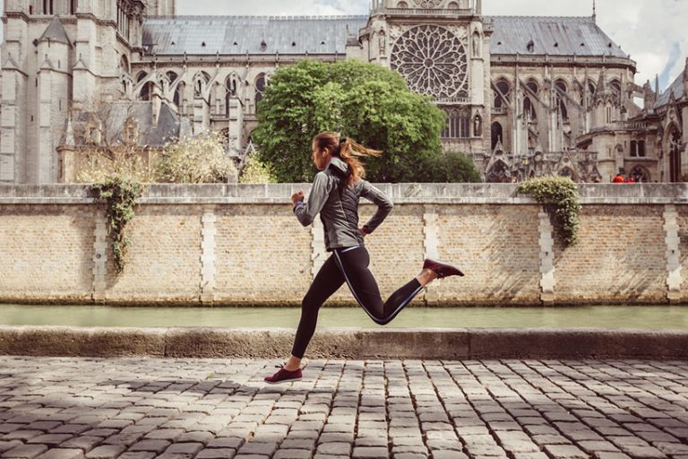 Sports woman jogging in Paris Young woman sports training outside