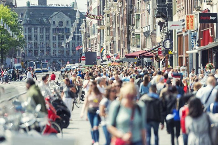 Amsterdam the Netherlands Horizontal color image of a crowded Damrak in Amsterdam. No social distancing applied.