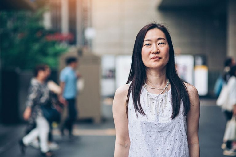 Japanese woman outdoors in the city Portrait of a middle aged Japanese woman standing outdoors with arms crossed