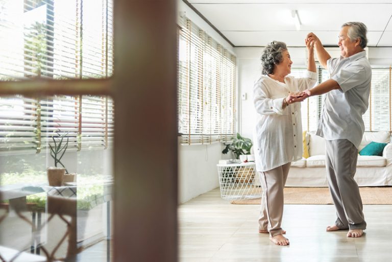 Romantic Romantic Asian Senior couple dancing at home. Happy Smiling Grandfather and Grandmother having fun Celebrating in wedding Anniversary day. Elderly man and woman holding hands together