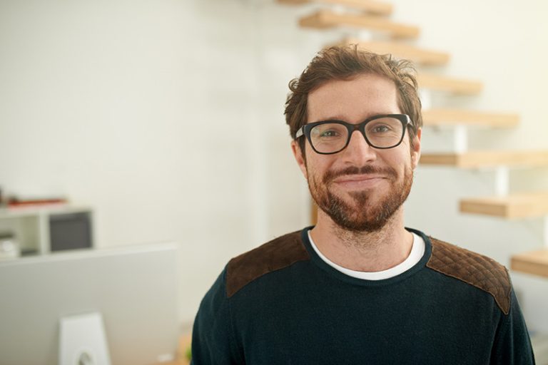 Shot of a young entrepreneur using a mobile phone Portrait of a confident young entrepreneur standing in his office
