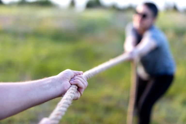 19-19-Hoe bedreigende taal fysiotherapeutische voorlichting kan ondermijnen-iStock-1226824358 Twee mensen zijn aan het touwtrekken, wat symbool staat voor een fysiotherapeut die aan de patiënt trekt. De patiënt zal dan weerstand geven.