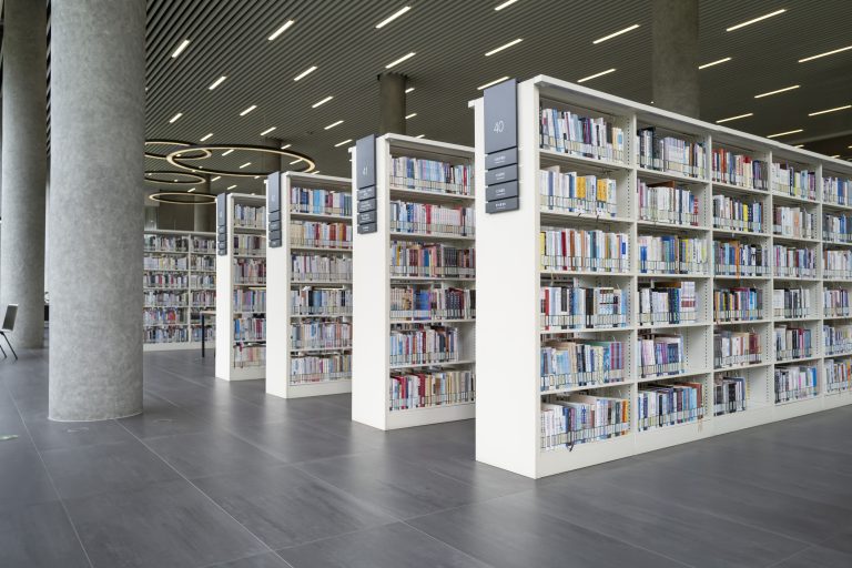 Moderne universiteitsbibliotheek met rijen boekenkasten vol met boeken.
