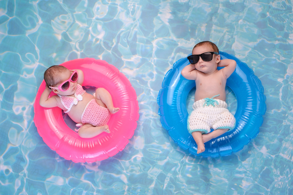 Twee kindjes op zwembandjes in het water alsof ze een duo vormen.