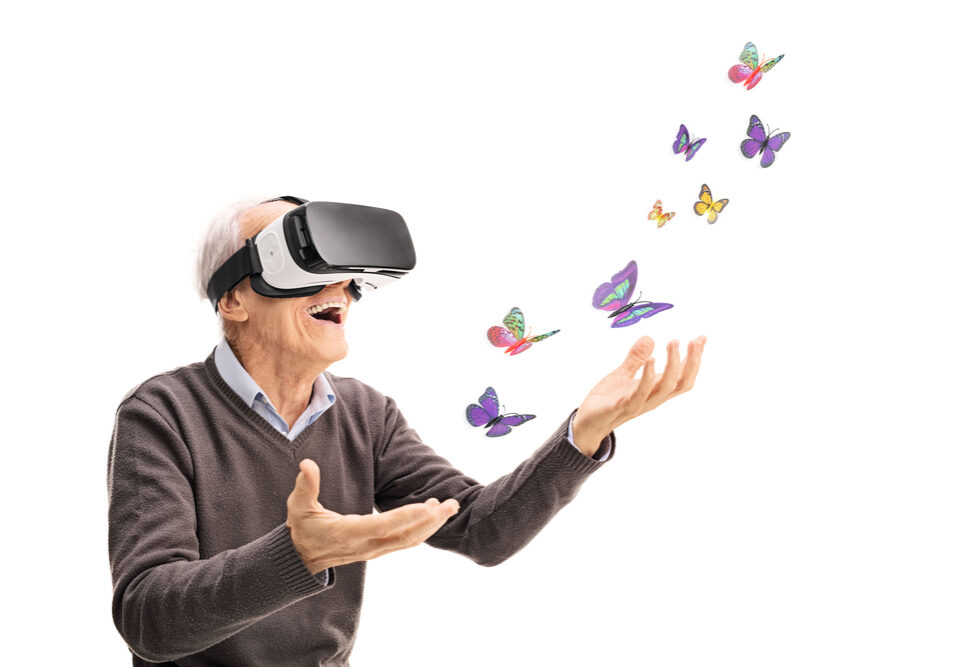 Oude man met exergame op heeft plezier.