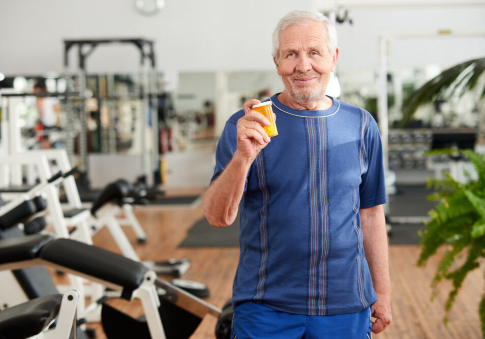 Blije oudere man die de bloeddrukverlagers laat zien die hij door sport nu minder nodig heeft.