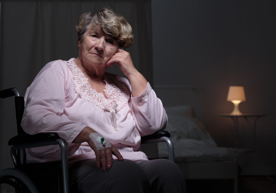 Sombere oudere vrouw in verpleeghuis die liever in haar eigen huis was.