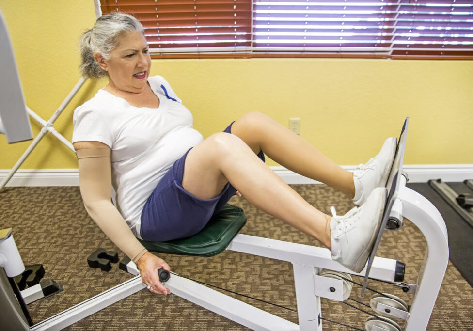Caucasian senior woman using leg press as part of her rehabilitation. She is at the physical therapist and using the lower body machine to build strength in her leg muscles. She is wearing shorts, a t shirt and sneakers. Shot was taken with a Canon 5D Mark 3.  rm